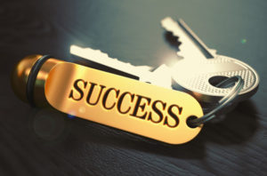 40197996 - keys to success - concept on golden keychain over black wooden background. closeup view, selective focus, 3d render. toned image.